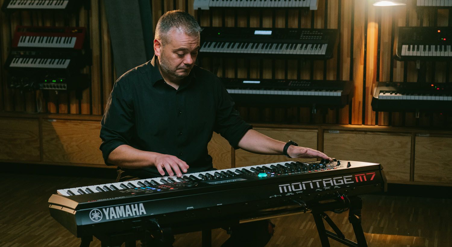 Man playing Yamaha synthesizer.