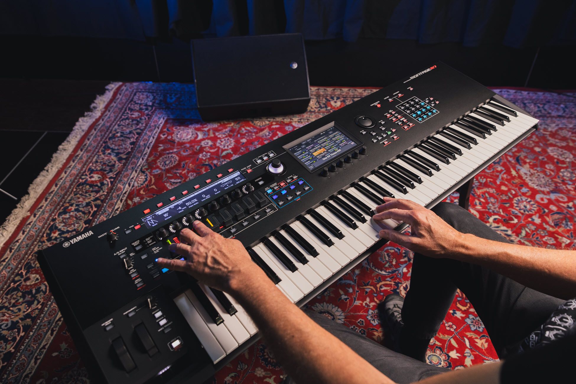 Closeup of someone's hands playing a synthesizer.